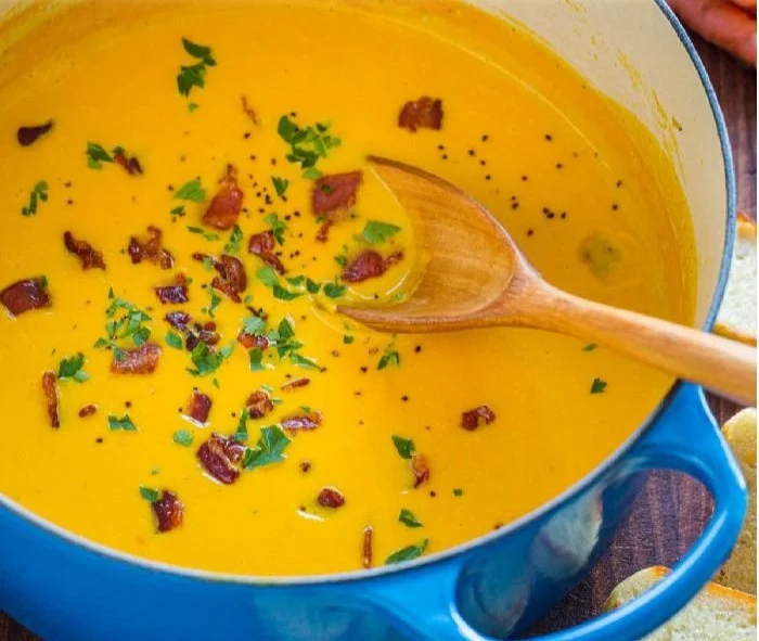 Bowl of best creamy carrot soup garnished with herbs and spices