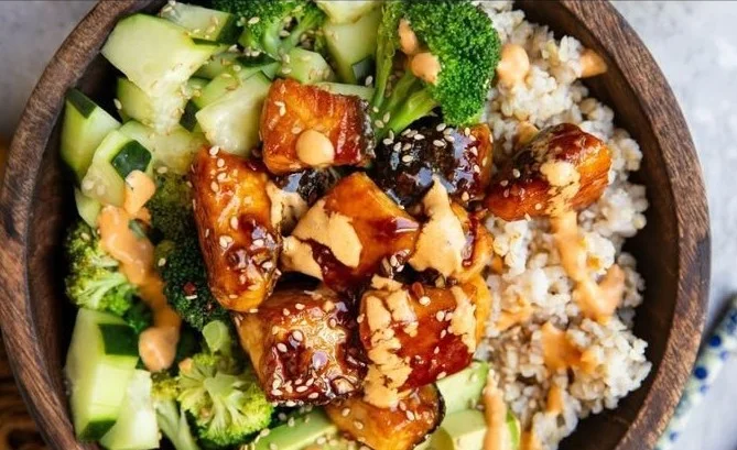Crispy Bang Bang Salmon Bite Bowls with colorful vegetables and a savory sauce
