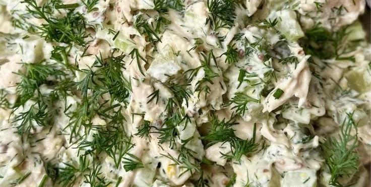 Bowl of easy dill pickle chicken salad garnished with herbs