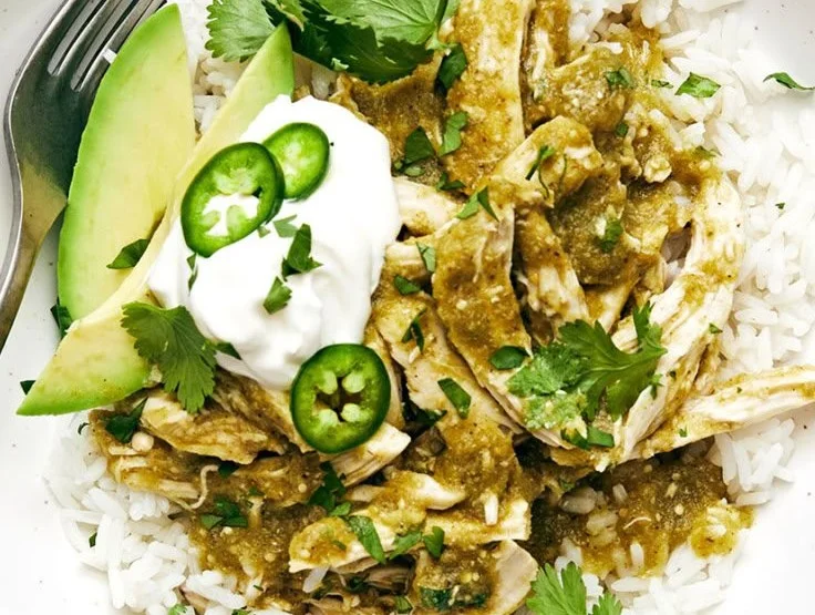 Delicious Green Sauce Crockpot Chicken served with fresh herbs.