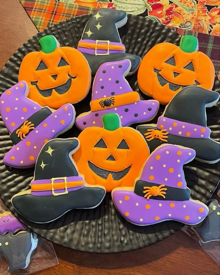 Colorful Halloween cookies shaped like ghosts, pumpkins, and bats.