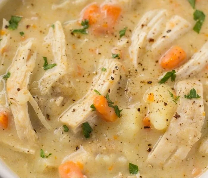 Healthy Chicken Pot Pie Soup with vegetables and herbs in a bowl
