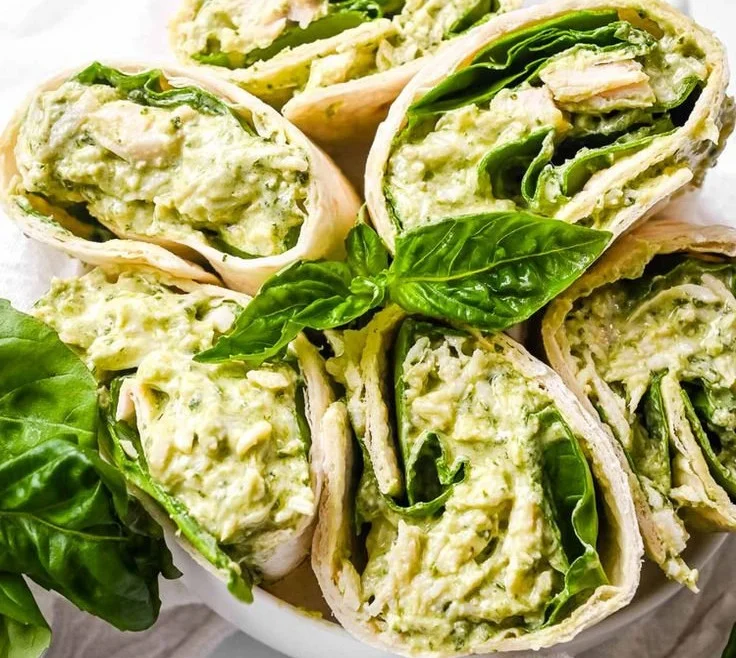Healthy pesto chicken salad with rotisserie chicken topped with fresh herbs and vegetables.