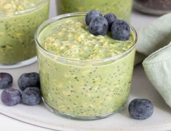 Delicious and healthy matcha overnight oats in a jar topped with berries and nuts.