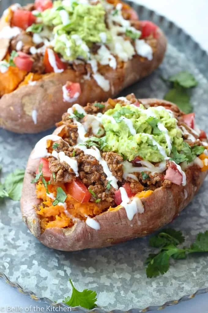 Taco stuffed sweet potatoes topped with fresh ingredients and spices