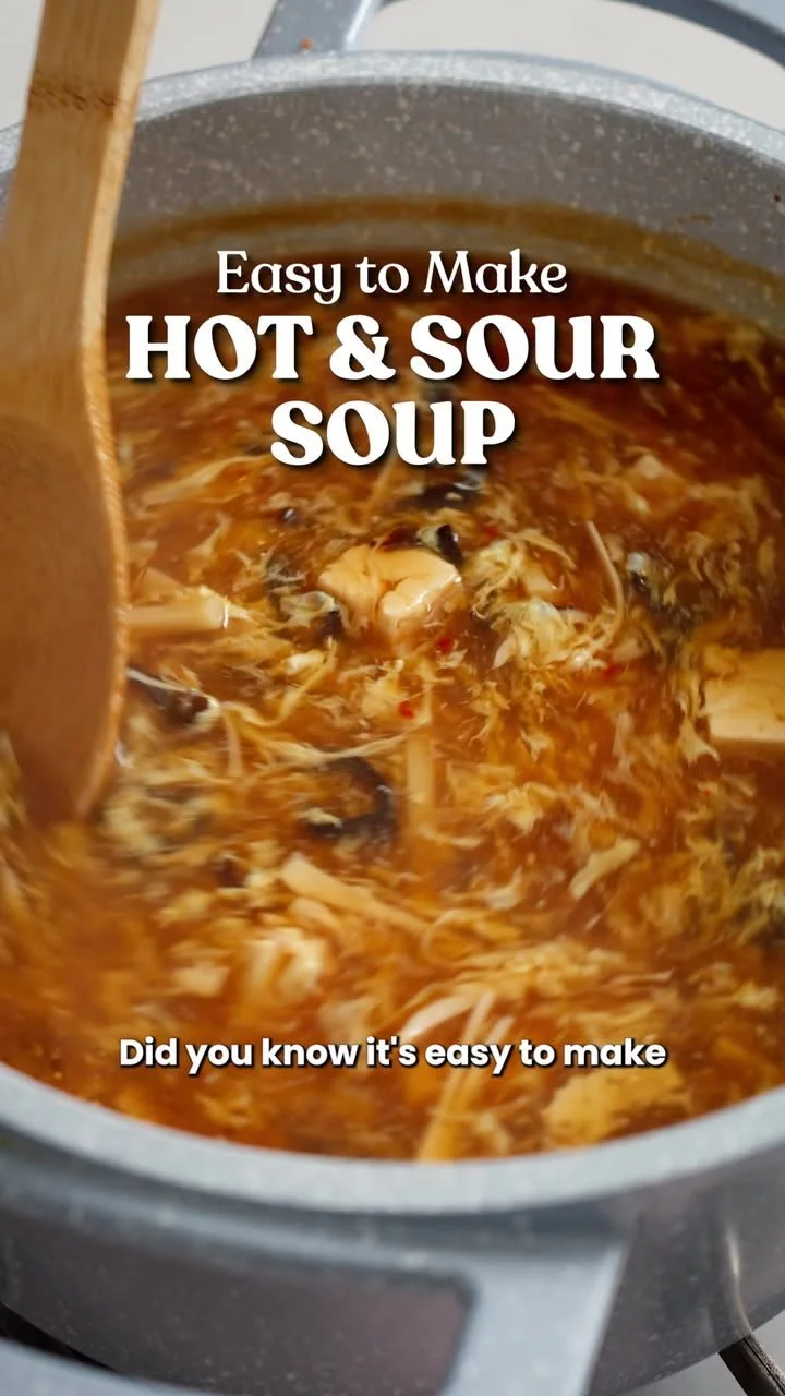 A bowl of hot and sour soup with fresh ingredients and vibrant colors.