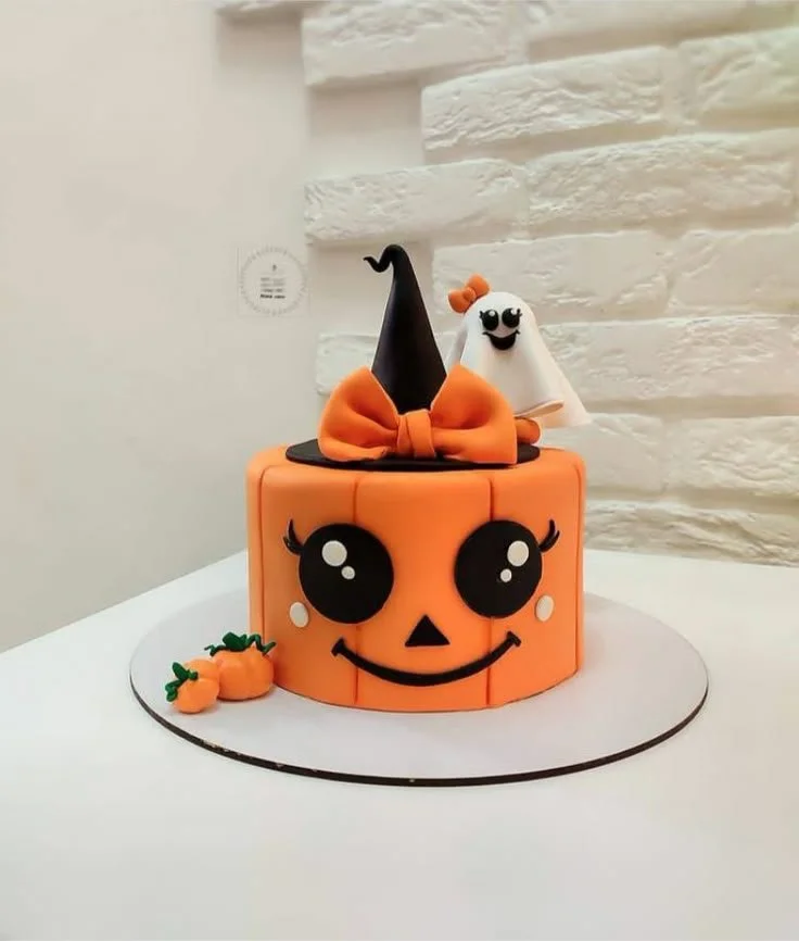 Jack o Lantern Cake designed with fondant pumpkins and spooky decorations.