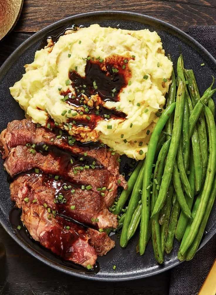 Juicy ribeye steak served with roasted garlic pan sauce on a plate
