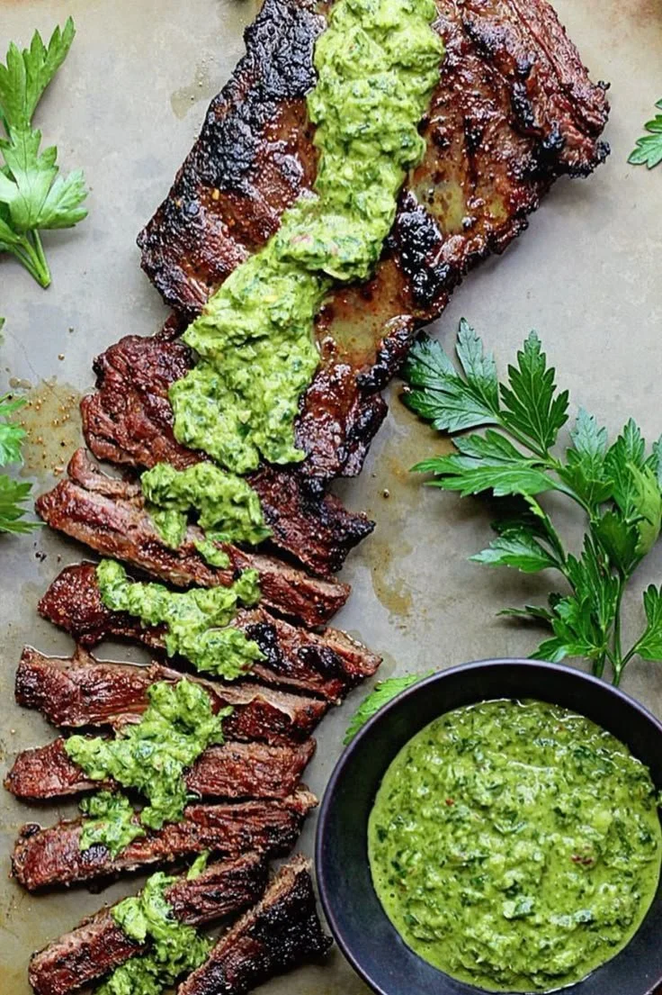 Skirt steak marinated in chimichurri sauce on a grill, ready to serve.