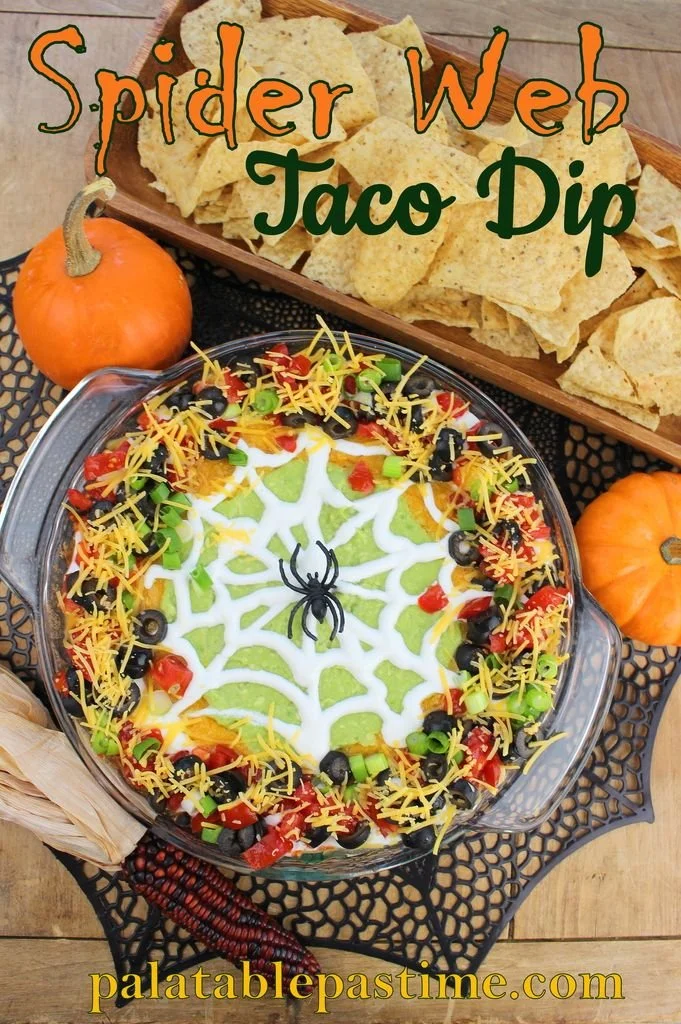 Spider Web Taco Dip garnished with sour cream and olives for Halloween-inspired fun