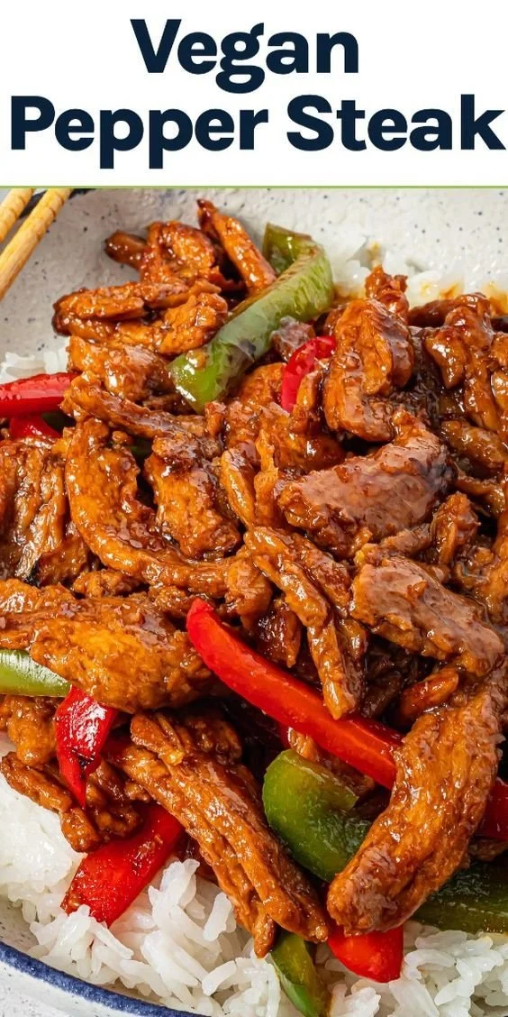Plate of vegan pepper steak with colorful bell peppers and spices